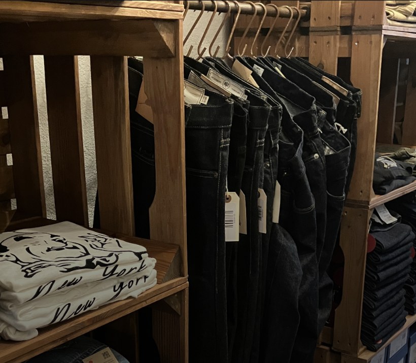 Holzkisten mit Raw Denim und gefalteten T-Shirts im Laden