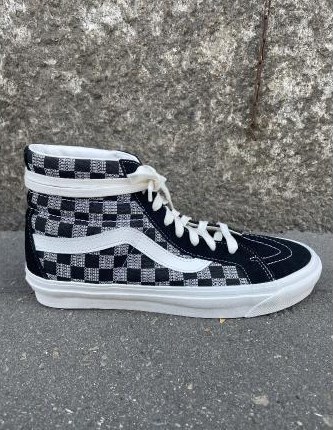 Karierter High-Top-Sneaker vor Steinmauer