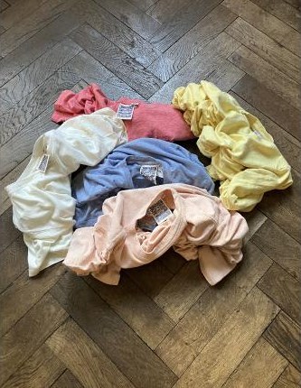 Garment-dyed T-Shirts, gefaltet auf Parkett