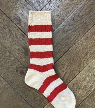 Rot gestreifte Wollsocken auf Parkett