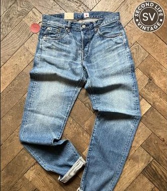 Verblichene Jeans auf Fischgrätparkett